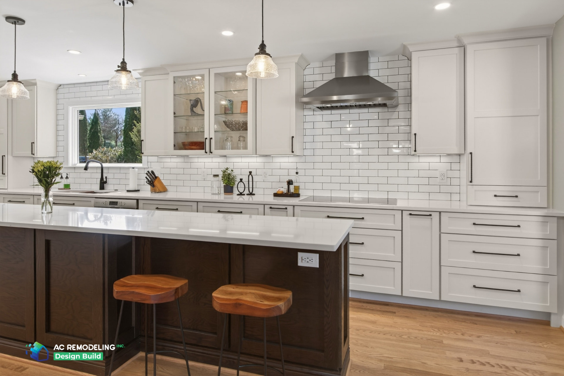 White kitchen with dark wood island, quartz counters and stainless hood