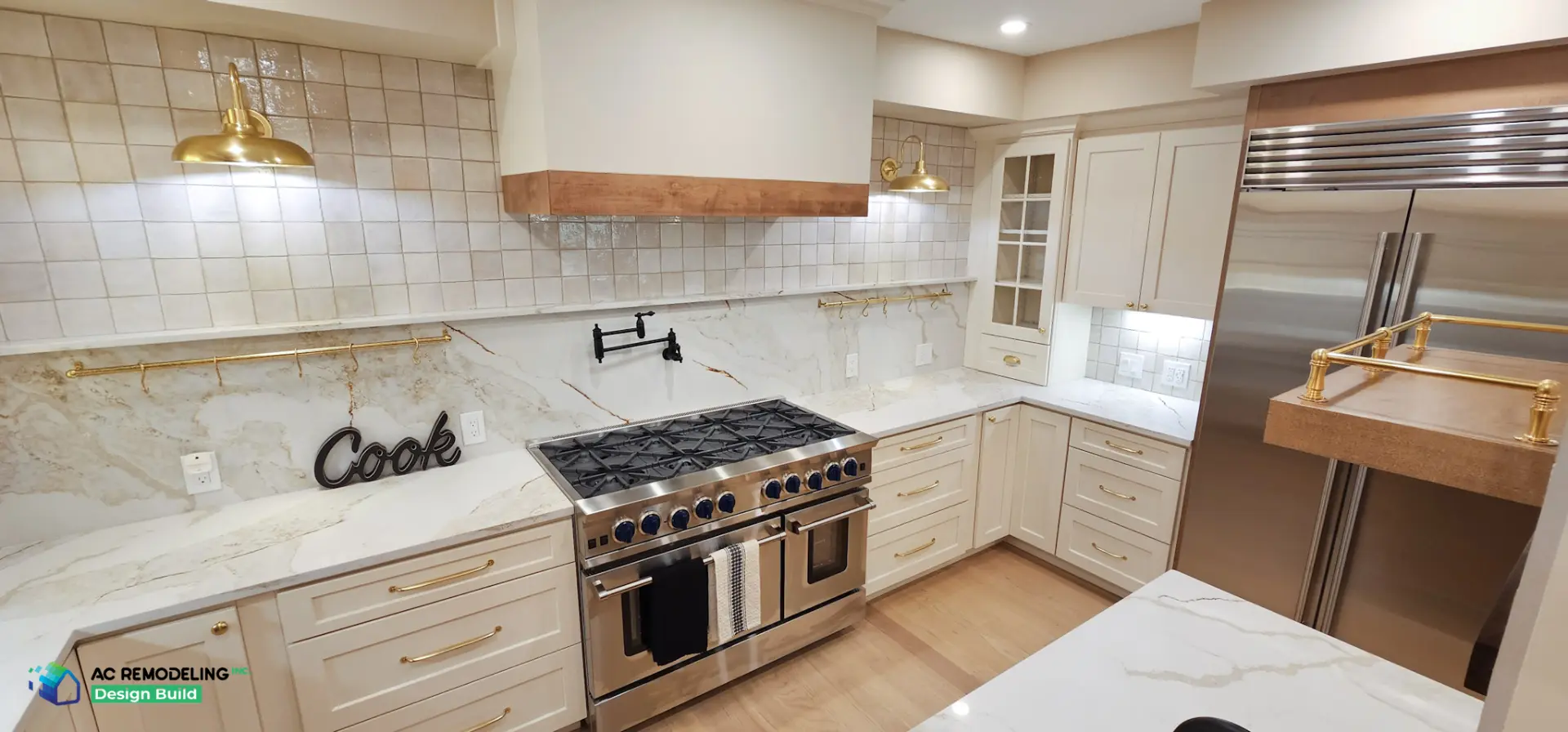 Cream kitchen corner with brass sconces, square tile backsplash and pro range