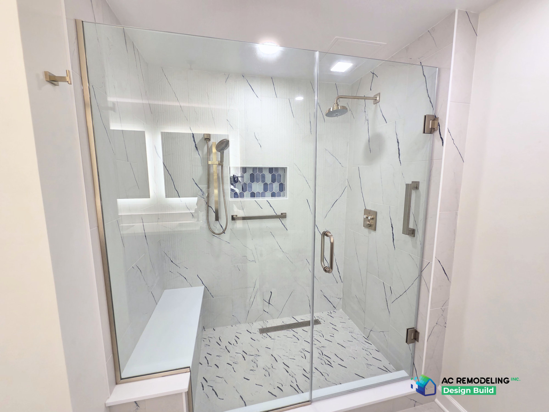 Wide view of the walk-in shower with hand shower, rain head and quartz bench
