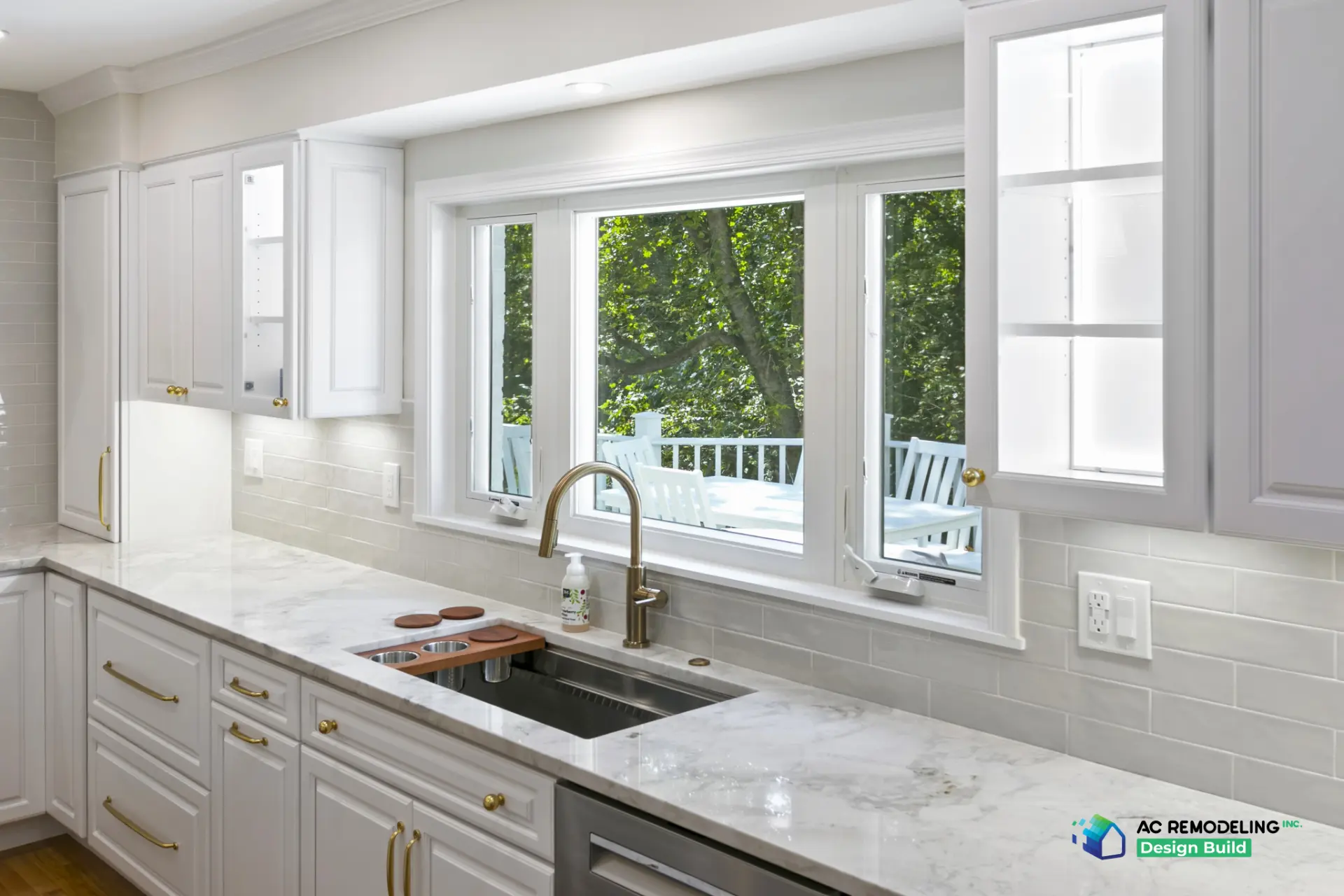 Marble counter with workstation sink beneath a wide bay window