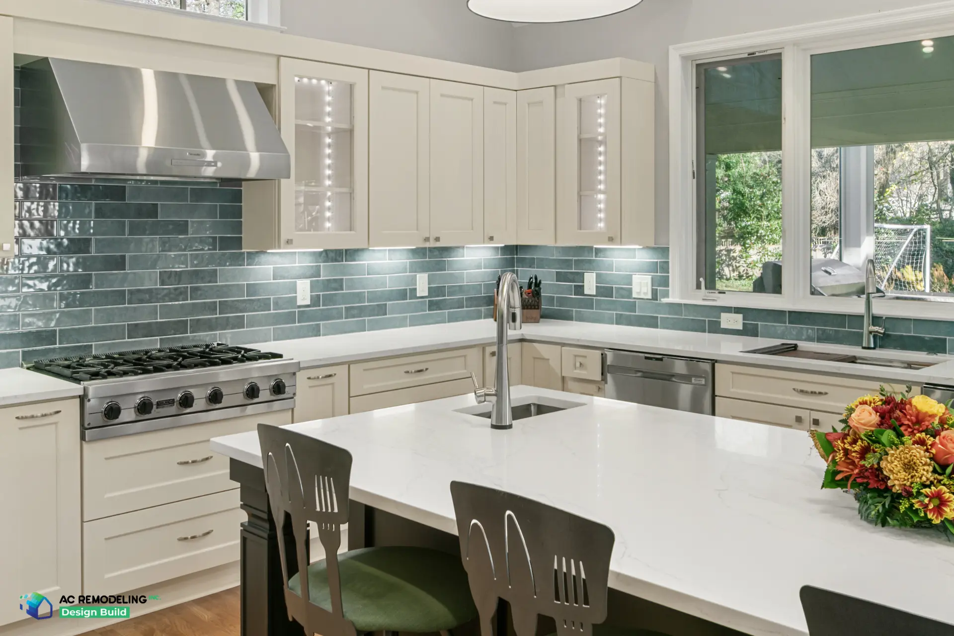 Viking range and stainless hood against the blue-green tile backsplash beside the prep sink island