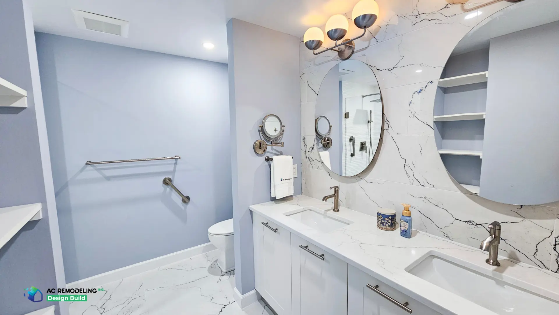 Primary bath vanity wall with marble slab backsplash, oval mirrors and glass shower