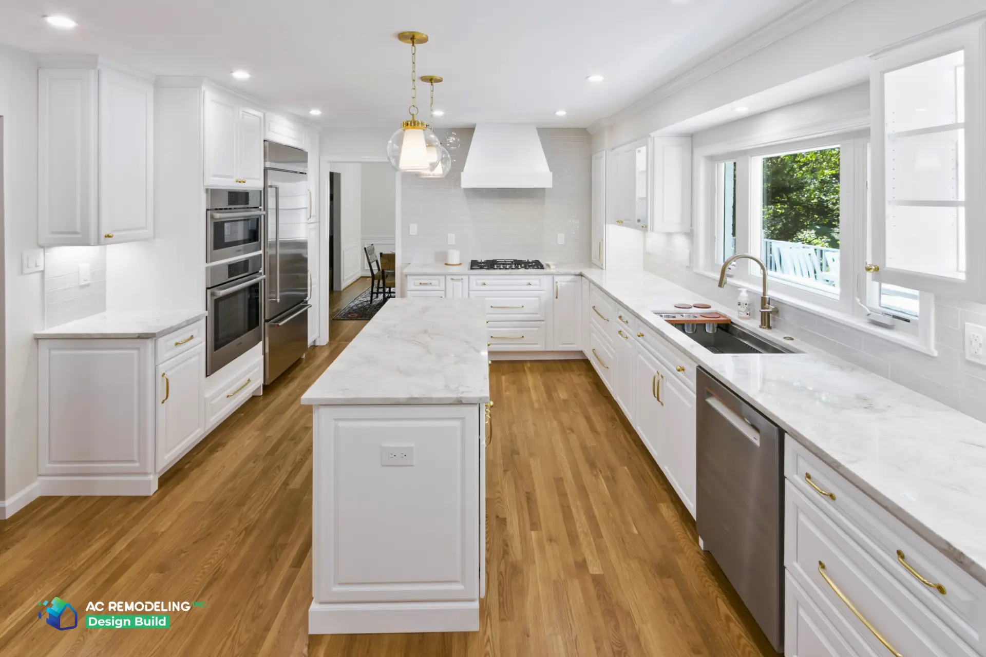 Full-length kitchen view with marble island and oak floors