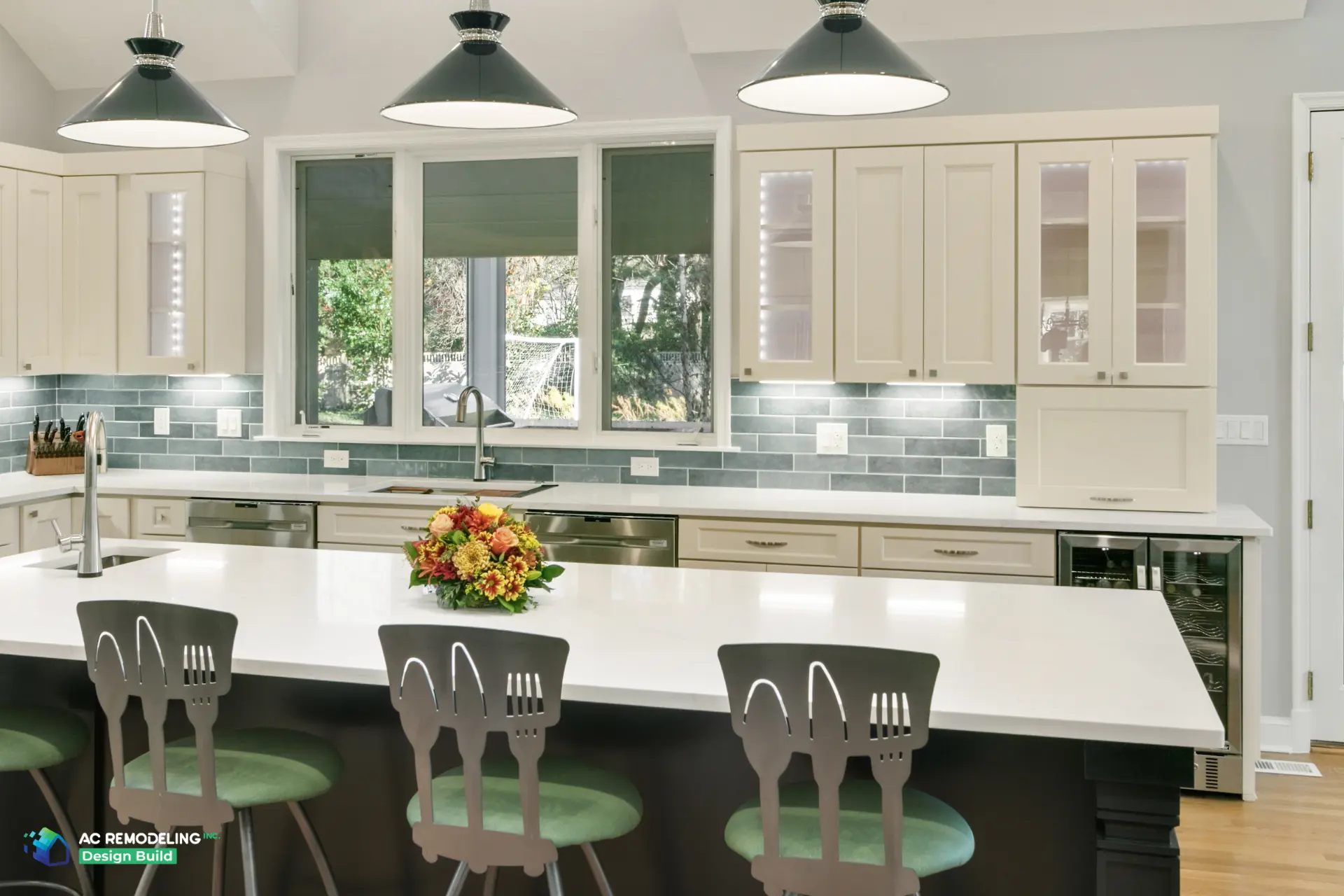 Island seating with green stools facing the window sink run and glass-front hutch