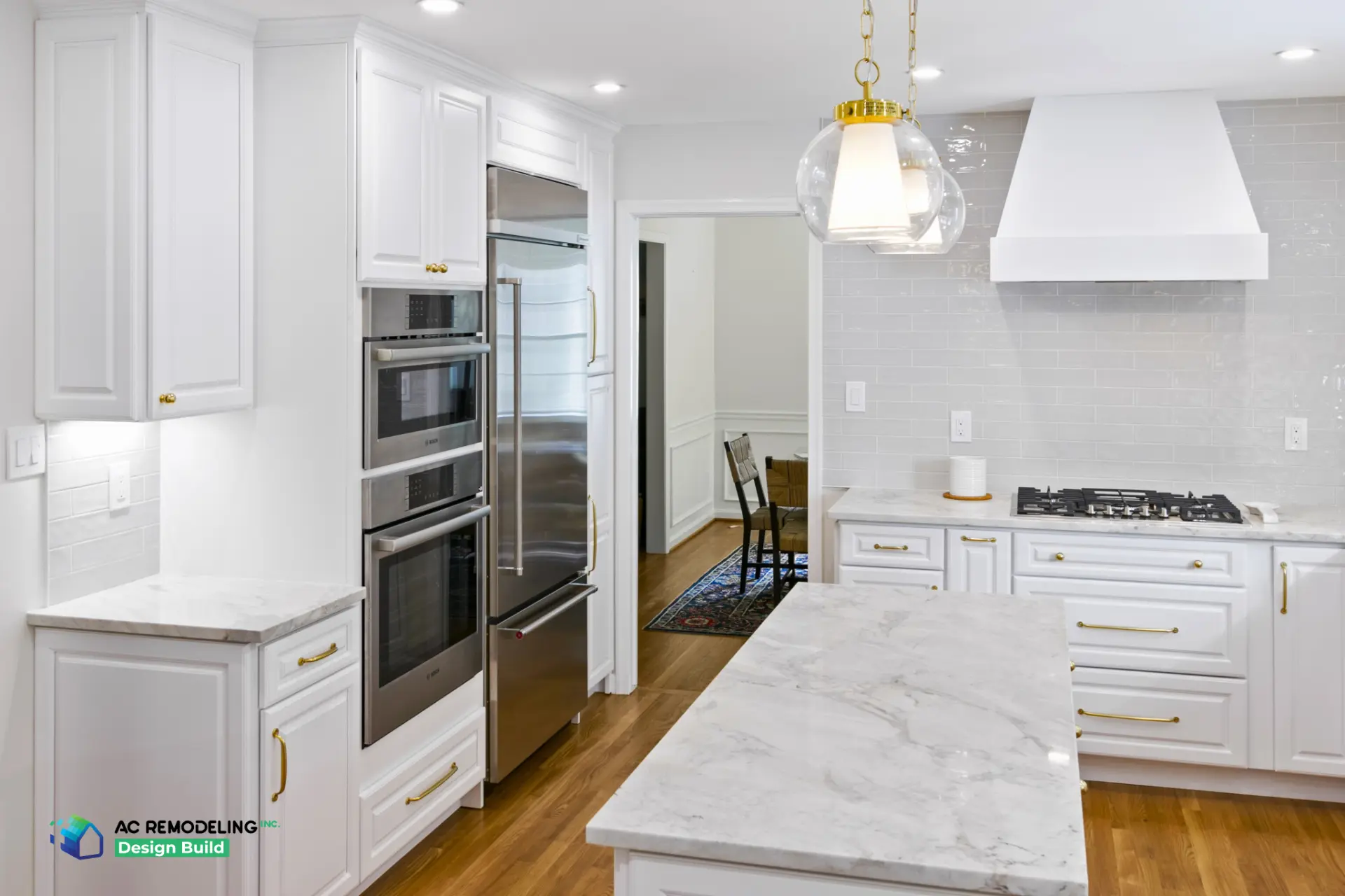 Bosch wall ovens, paneled refrigerator and white vent hood over cooktop