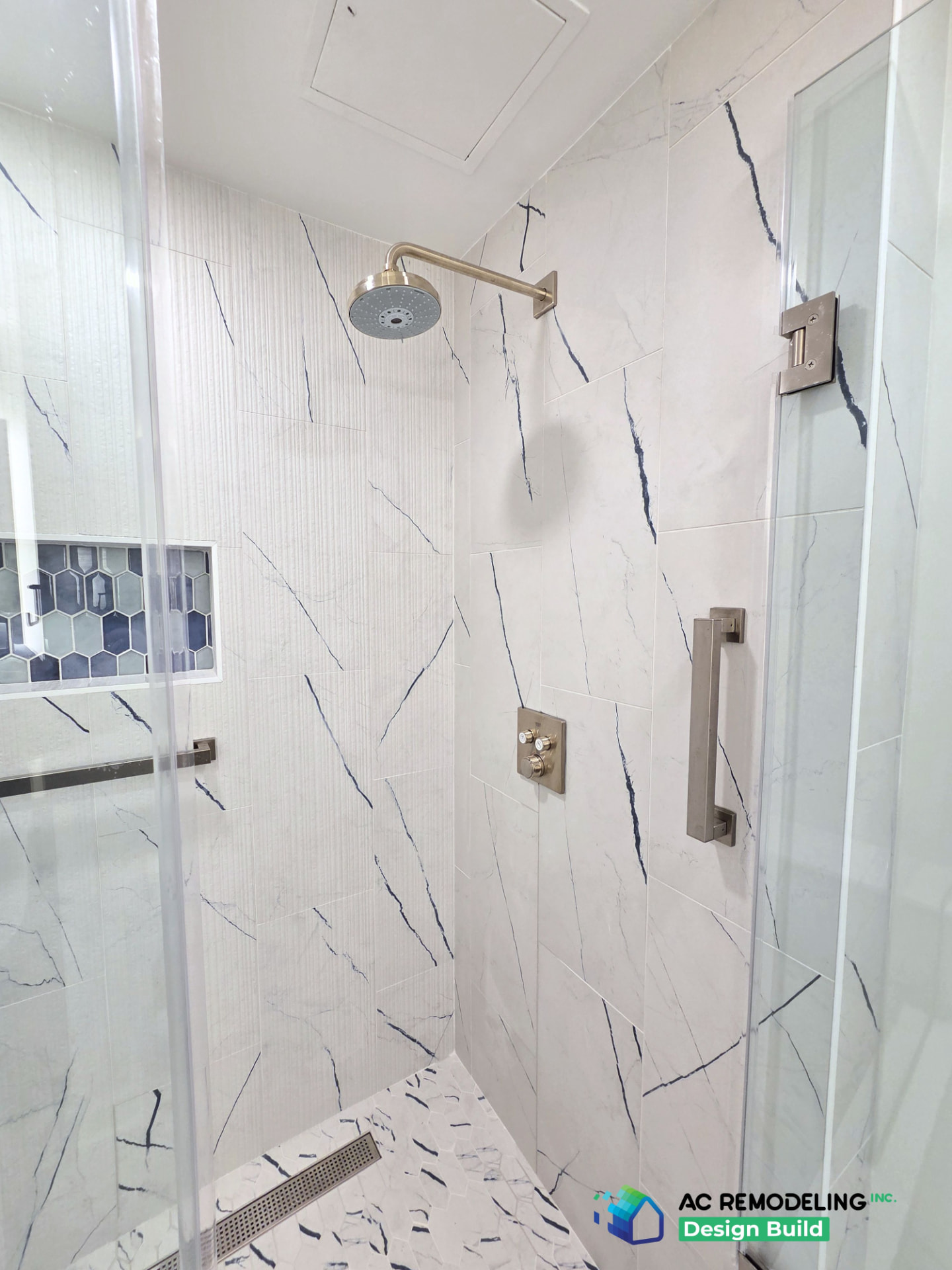 Close-up of the fluted and marble tile walls with brushed nickel rain head