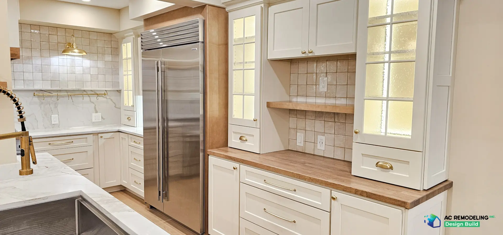 Built-in Sub-Zero refrigerator between cream cabinetry and glass display hutch