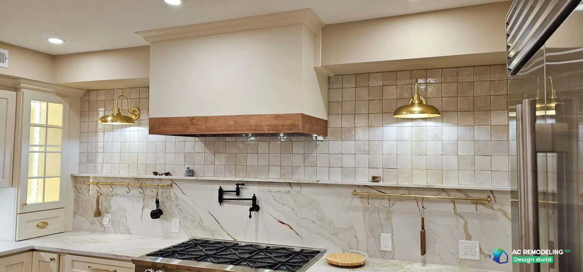 Wood-trimmed hood over the range wall with zellige tile and brass barn sconces