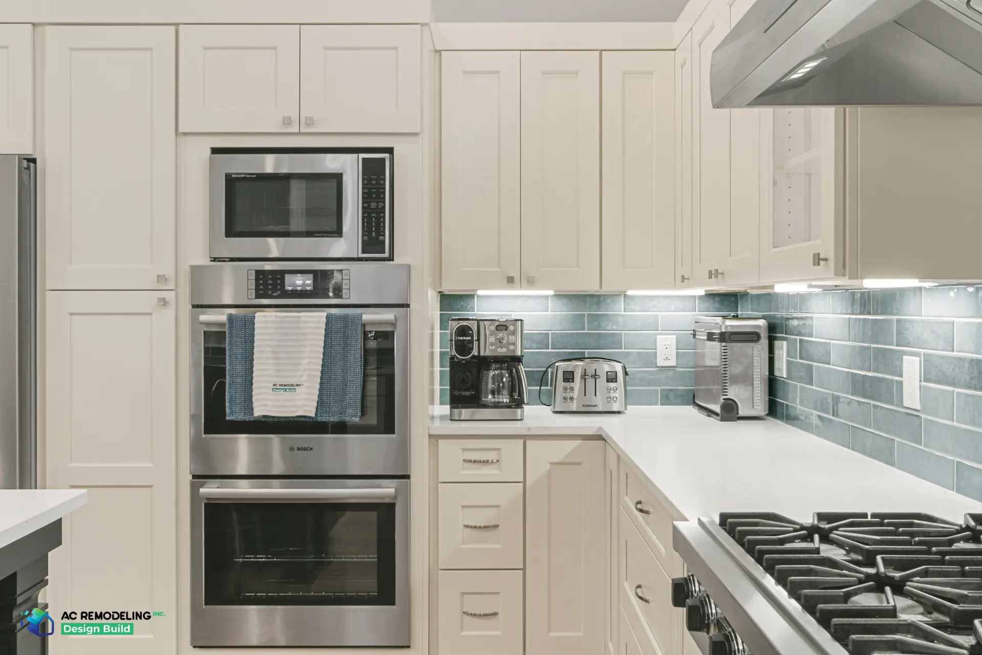 Coffee station with double wall ovens, microwave and blue-green tile backsplash