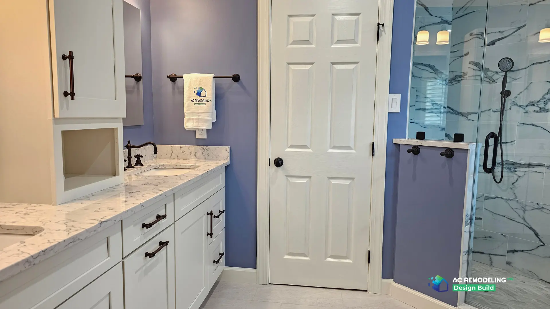 Vanity run with linen tower, marble-look quartz counter and view into the marble-tiled glass shower