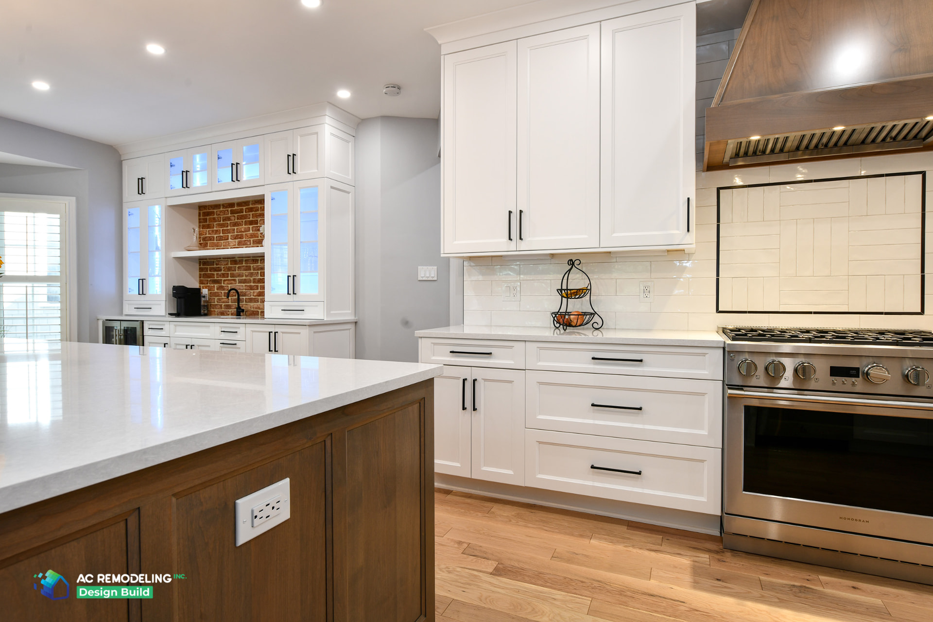 Remodeled kitchen with white shaker cabinetry, walnut island, quartz countertops and a wood range hood