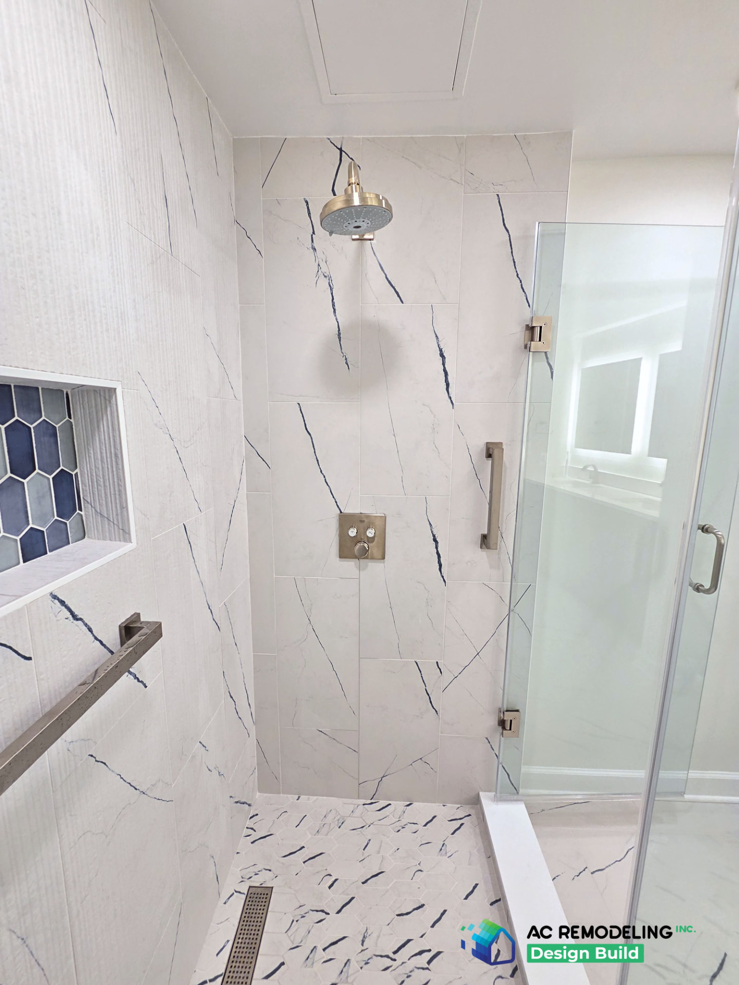Vertical view of the shower with brushed nickel rain head and fluted marble tile