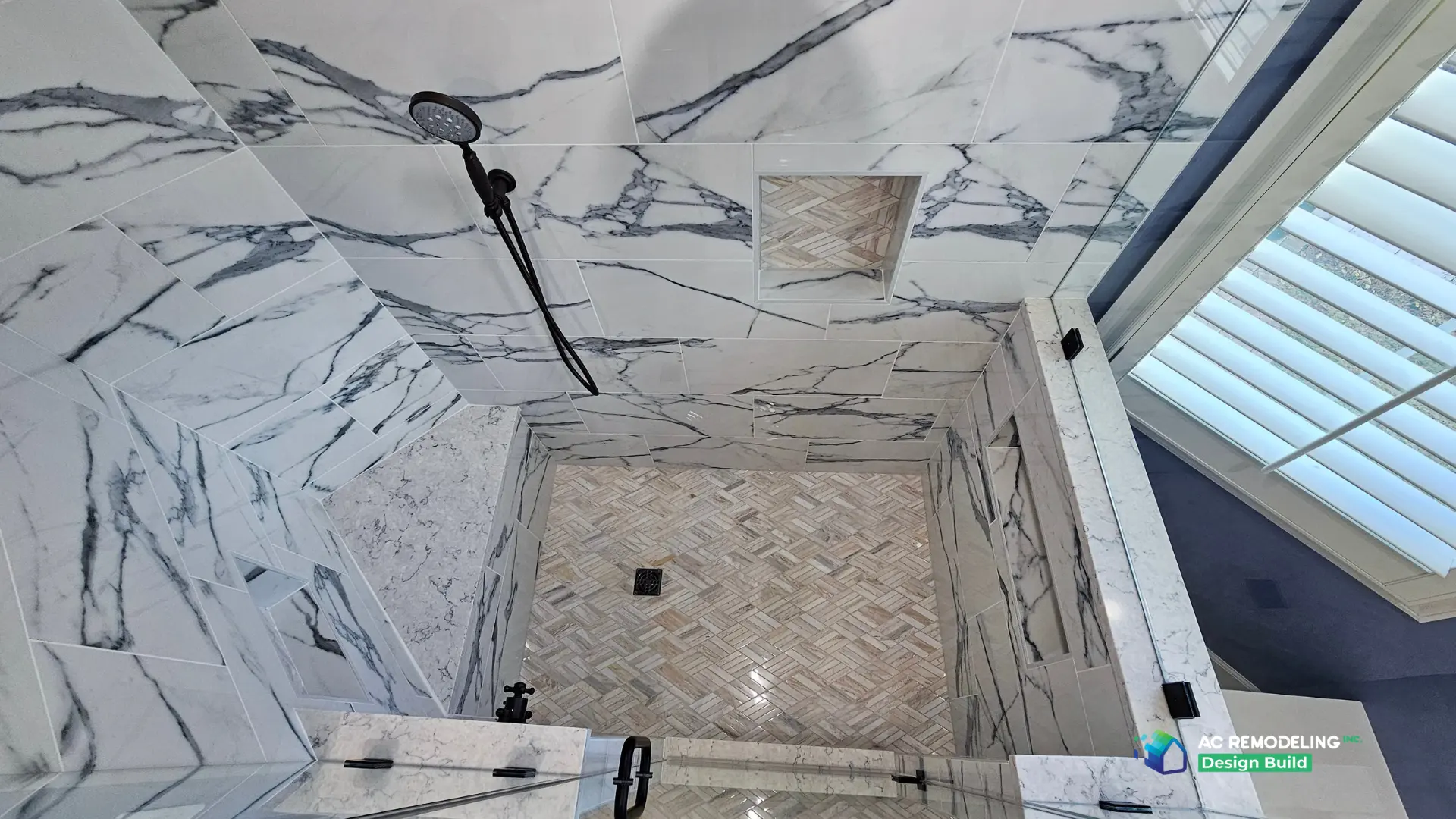 Overhead view of the marble shower walls, niche and herringbone stone floor