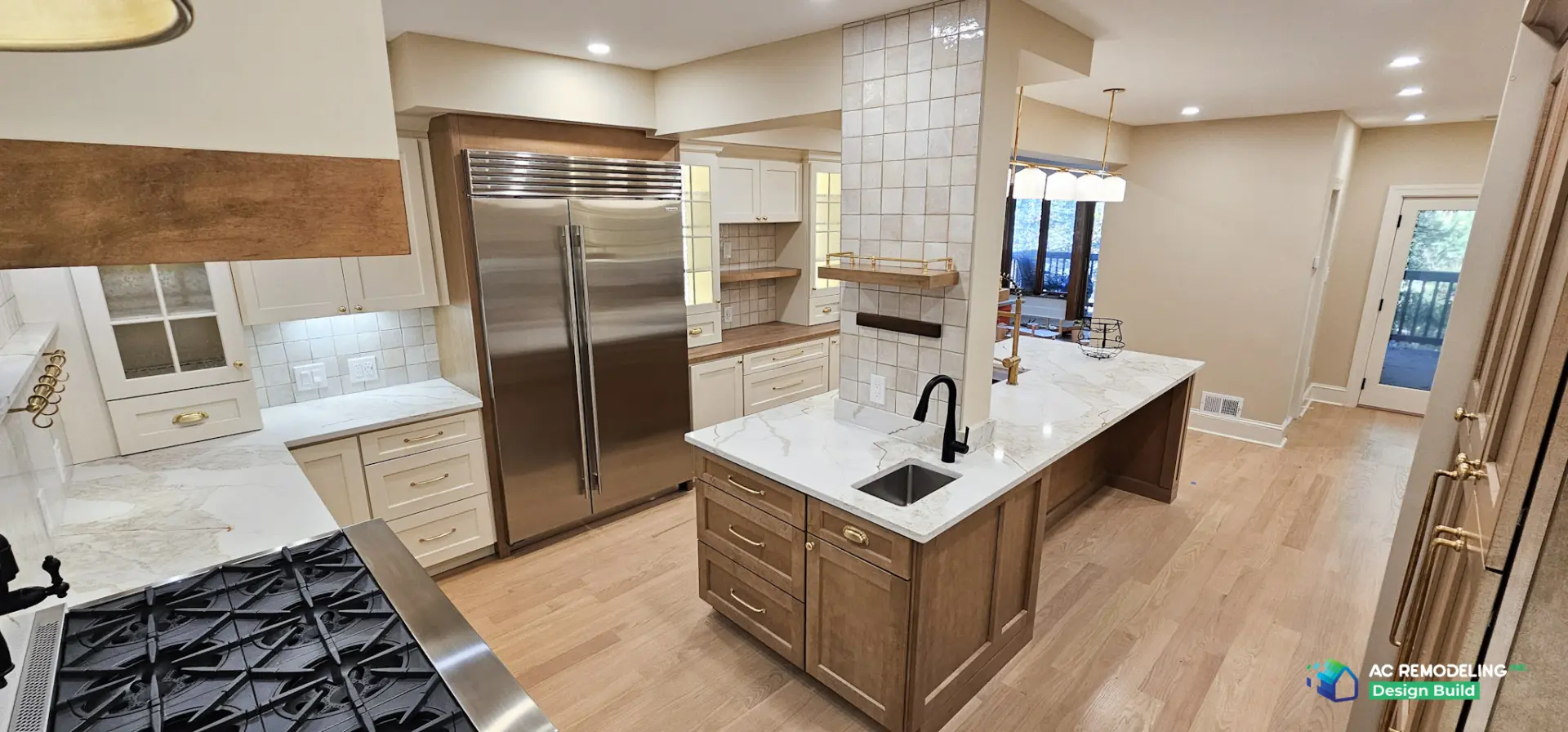 Stained wood island with prep sink, Sub-Zero refrigerator and dining pendants