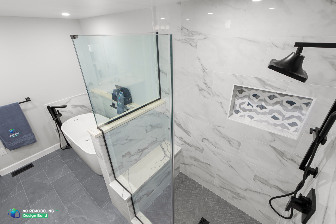 Glass shower partition with marble tile, mosaic niche and matte black shower head