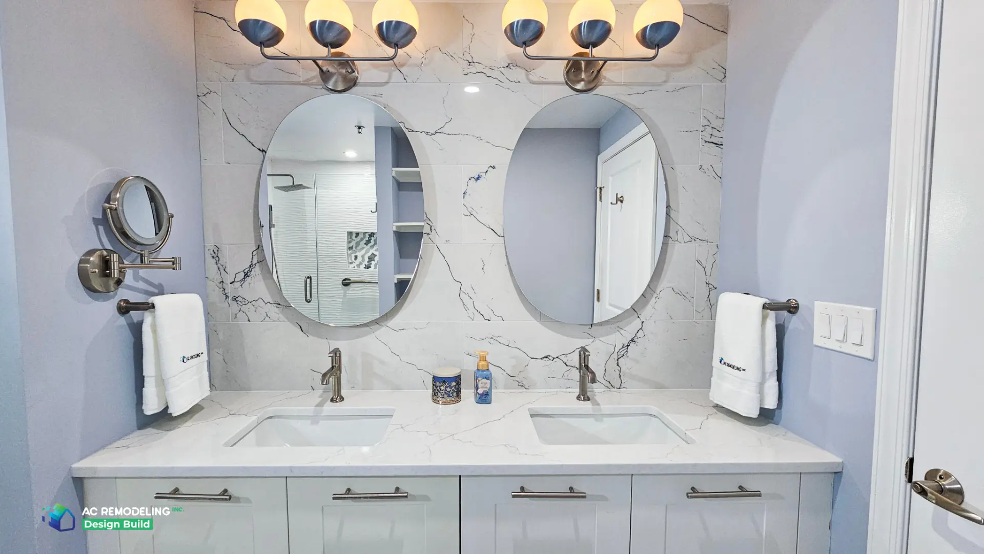 Symmetrical oval mirrors over the double quartz vanity with globe sconces