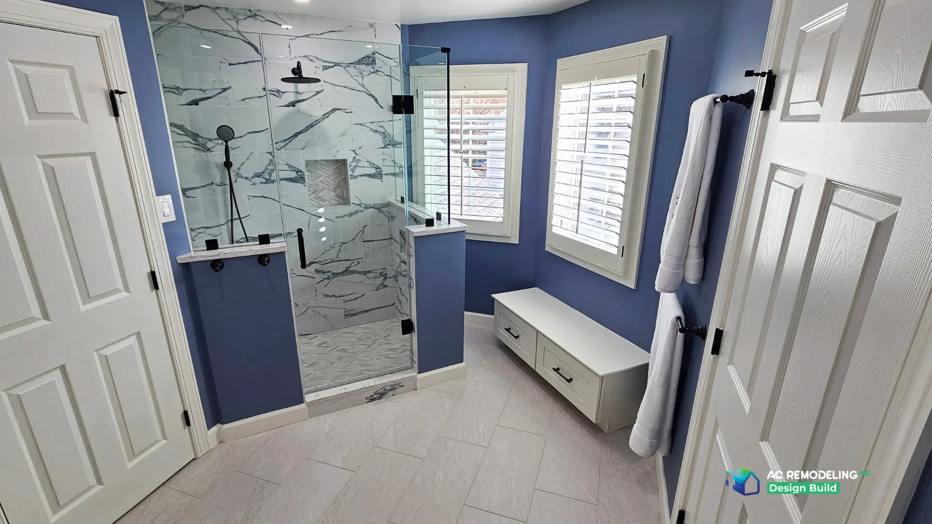 Blue primary bath with marble-tile corner shower, rain head and towel bars