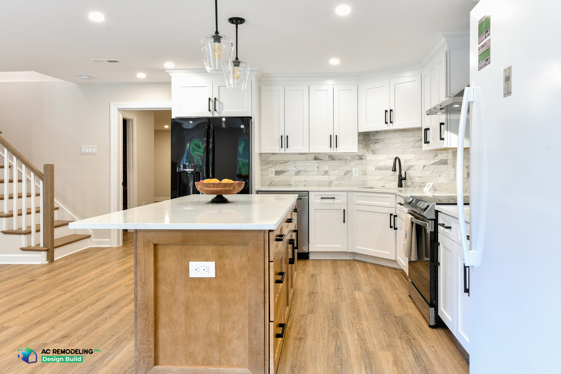 Rockville basement ADU kitchen with large quartz island, white cabinetry and glass pendant lights