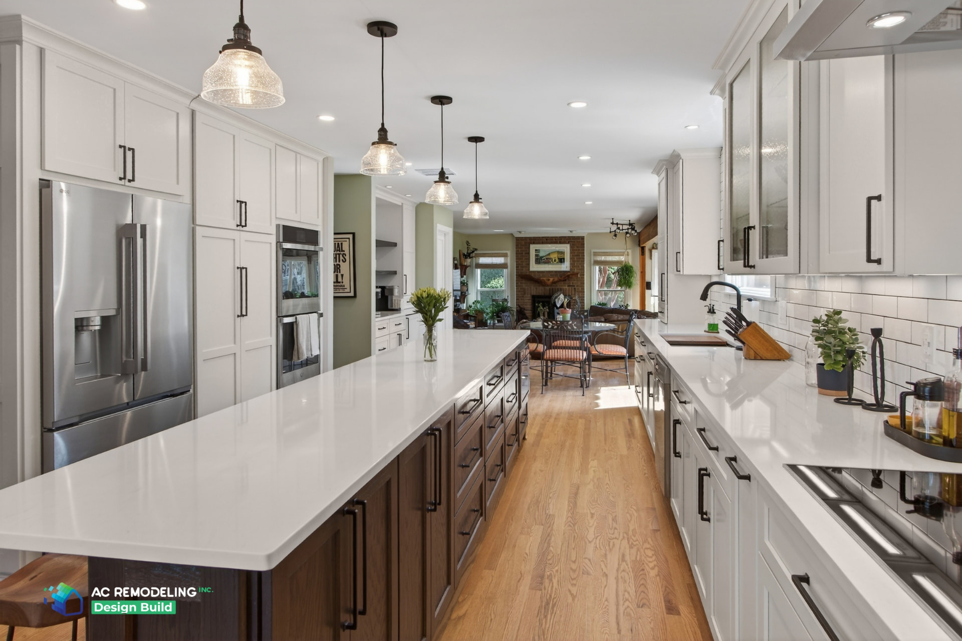 Wide galley view with stainless refrigerator, wall ovens and open sightline to the living room