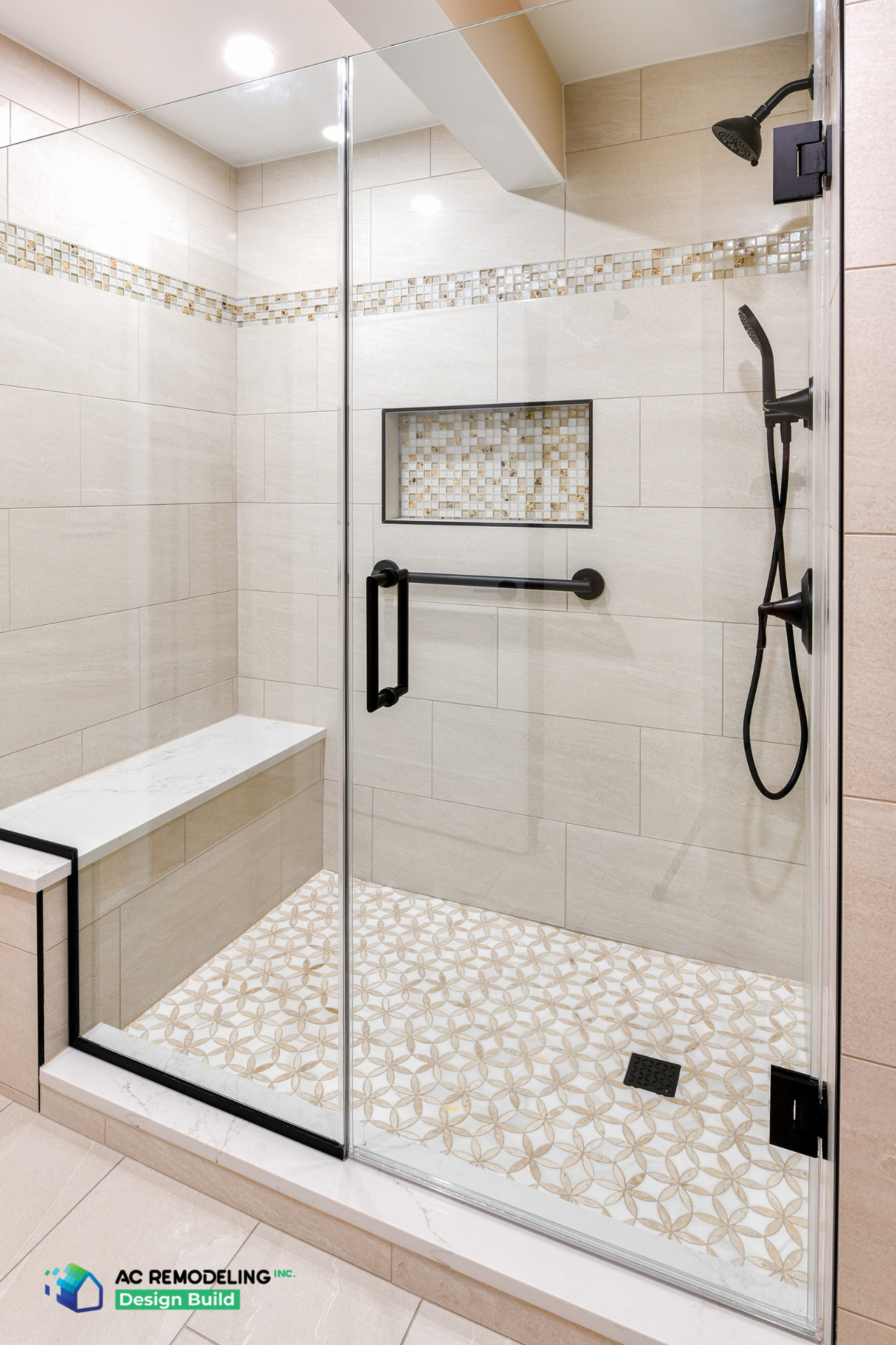 Walk-in shower with quartz bench, grab bar, mosaic niche and patterned tile floor