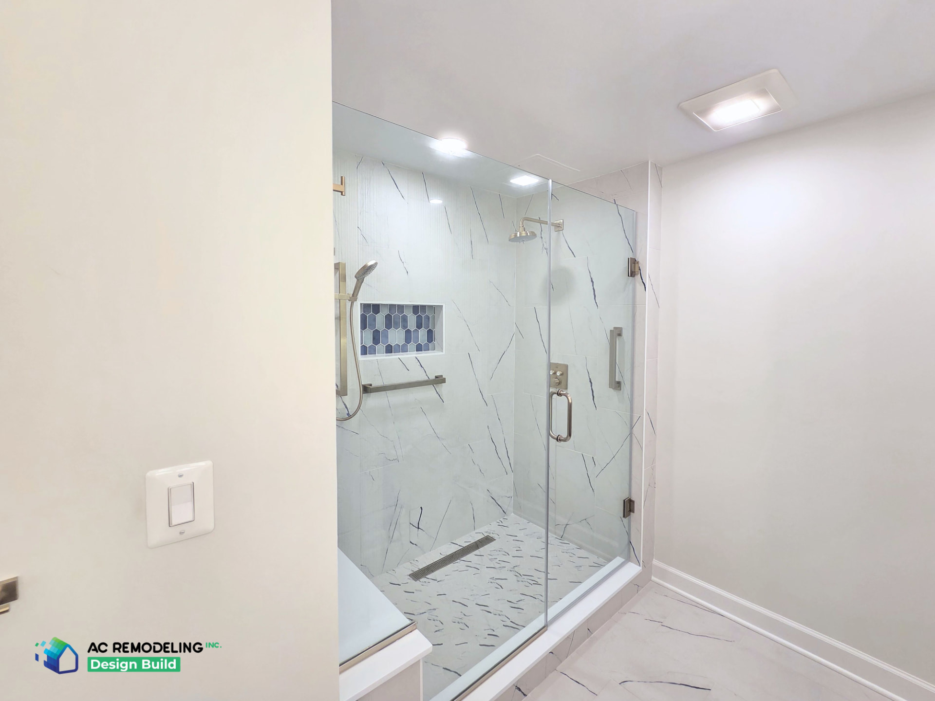 Shower entry from the vanity wall with marble-tile floor and glass door