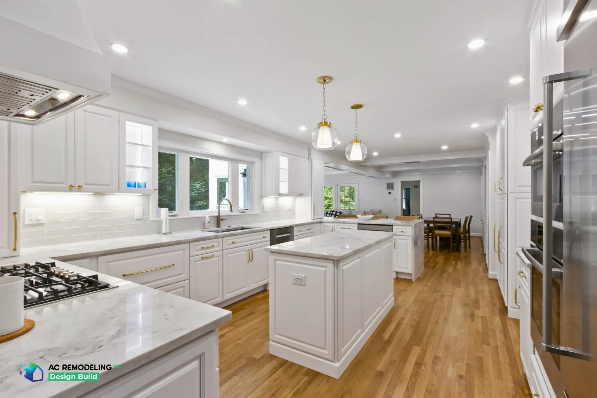Wide view of white kitchen with center island and dining area beyond