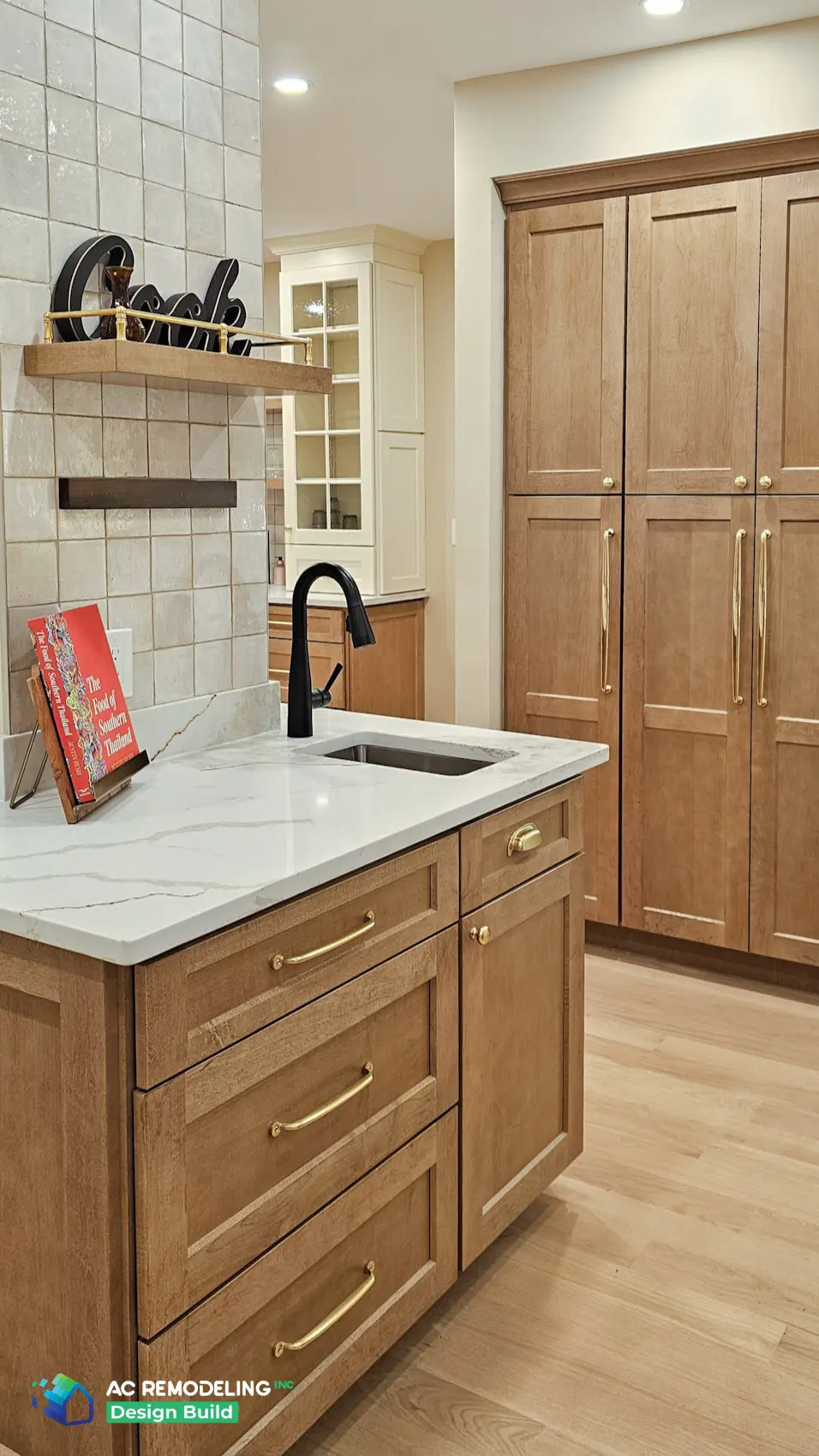 Prep sink island in stained wood with paneled floor-to-ceiling pantry