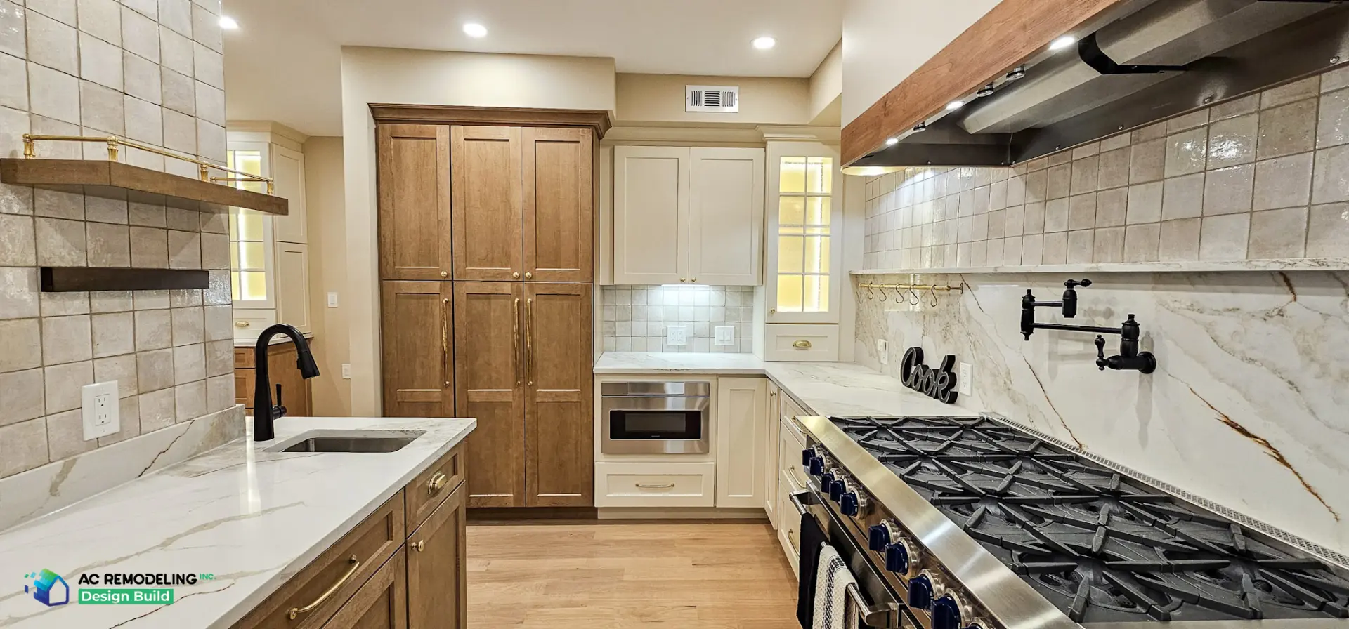 Galley view with quartzite counters, black pot filler and wood pantry wall
