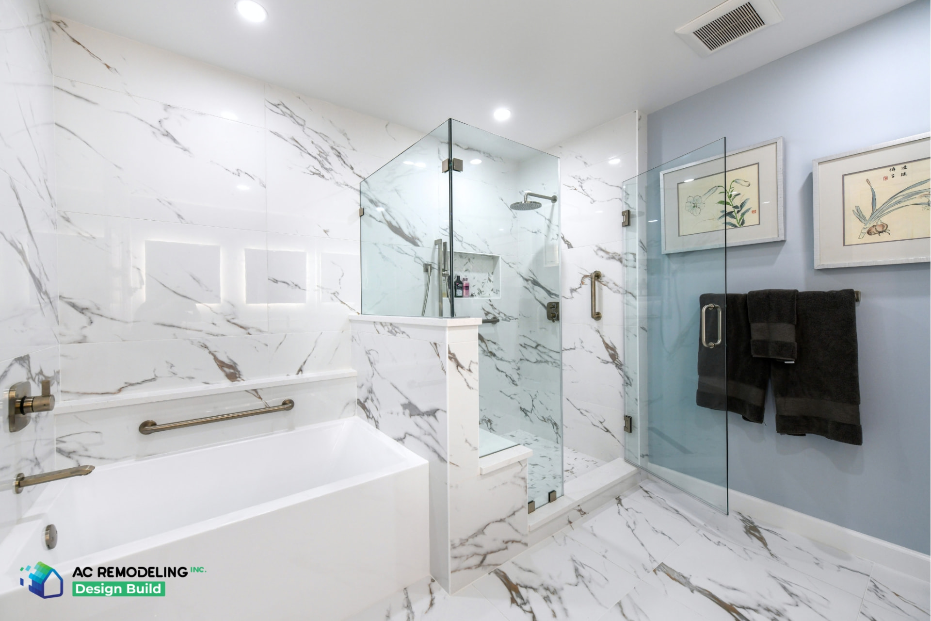 Primary bathroom with marble-look tile, glass shower and a ceiling exhaust fan grille beside the shower