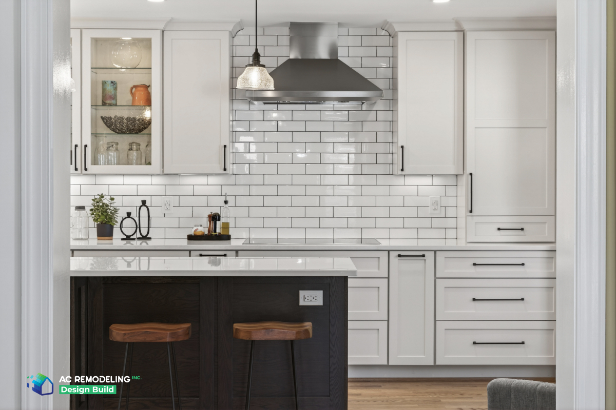Kitchen breakfast bar with wood stools, dark island and white shaker cabinetry