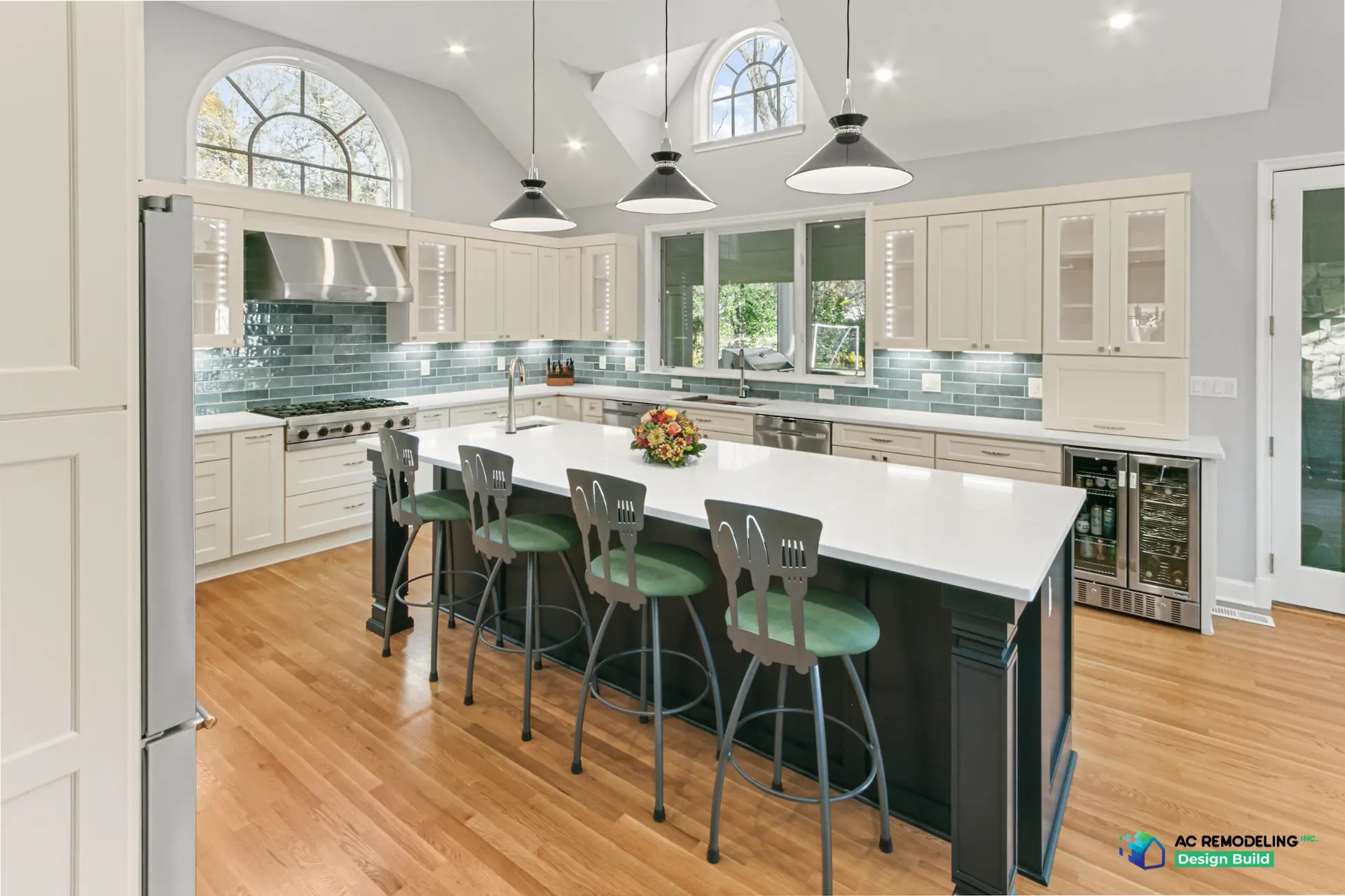 Seating side of the island with green upholstered stools and dual beverage refrigerators