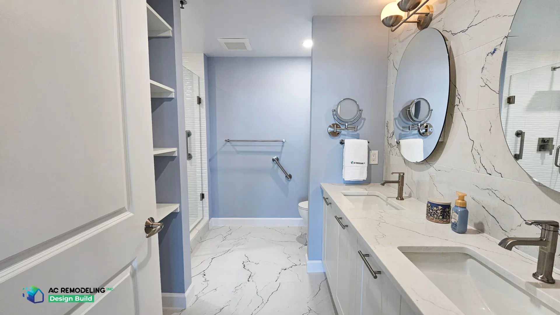 Long primary bath view with open linen shelving, glass shower and marble-look porcelain floor