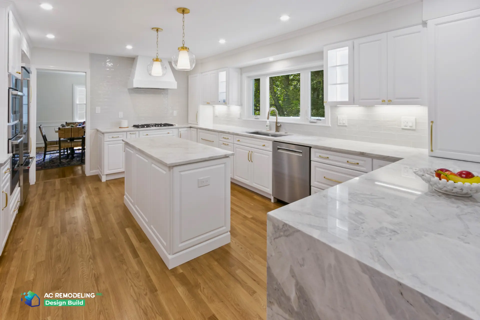 Bright kitchen with windows over sink and marble island with wood floors
