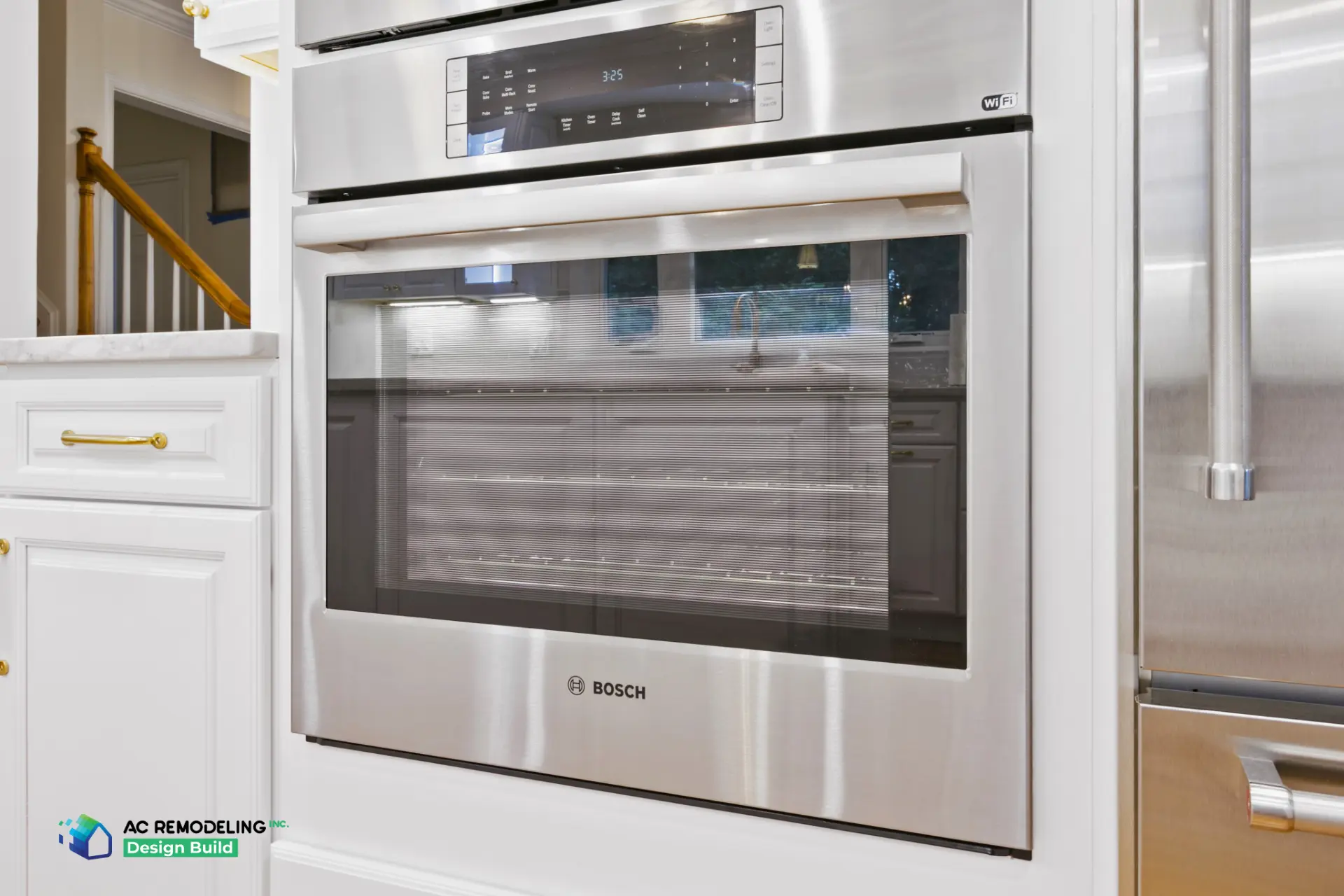 Built-in stainless wall ovens framed by white cabinetry with brass pulls