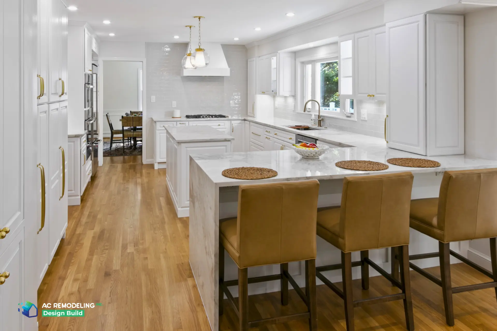 Full white kitchen with marble peninsula and leather counter stools
