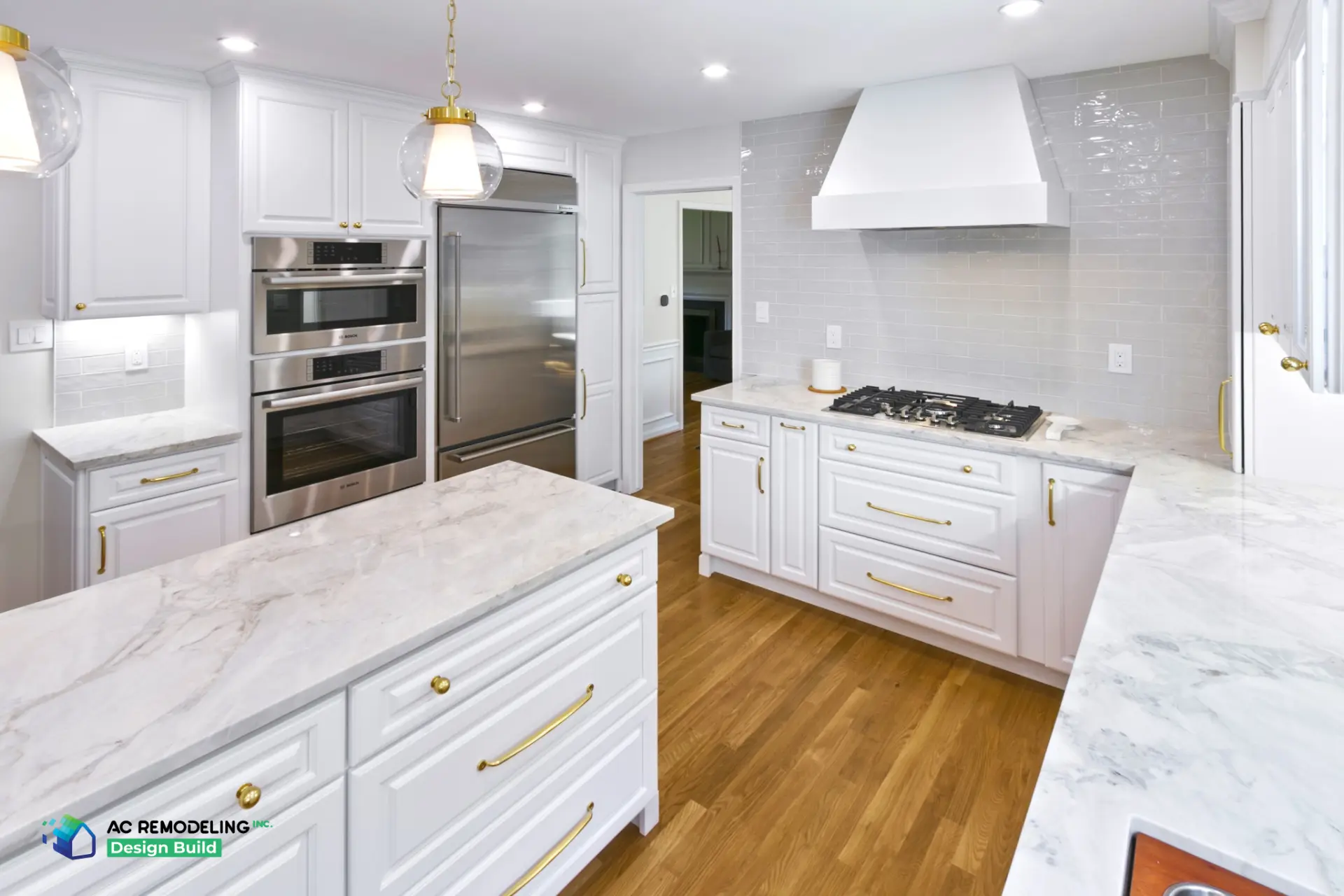 Gas cooktop under white hood with gray subway backsplash and marble island